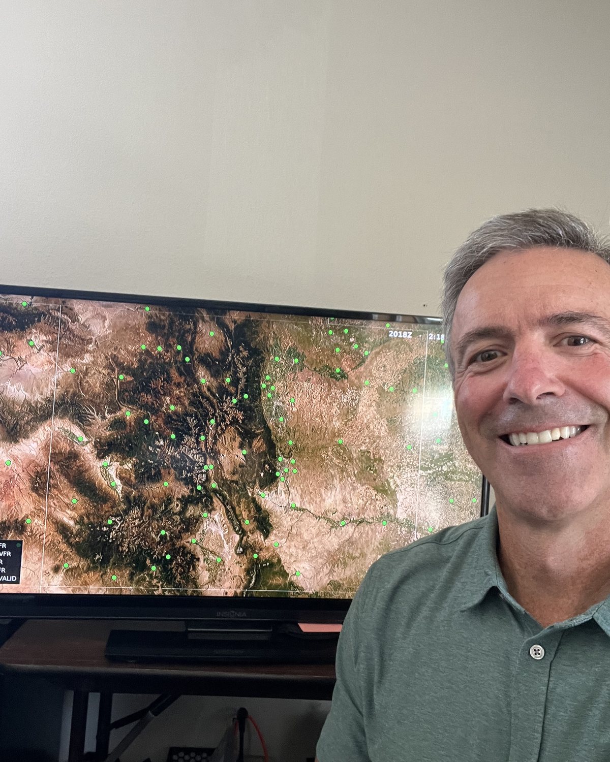 Jim Kasic, founder of AirCanvas, beside his AirCanvas map running live on the wall